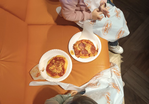 Dzieci jedzą pizze